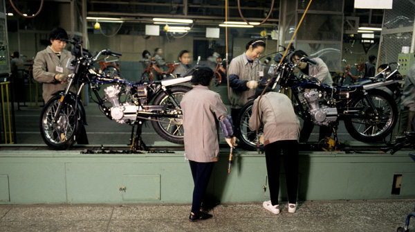 Workers assemble motorcycles