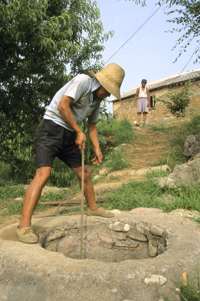 Peasant drawing water from well