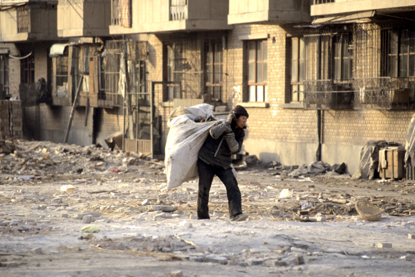 Woman salvages goods in demolished area