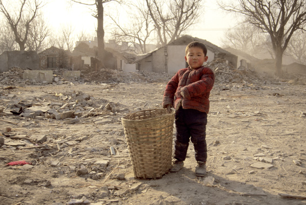 Child stands in razed neighborhood