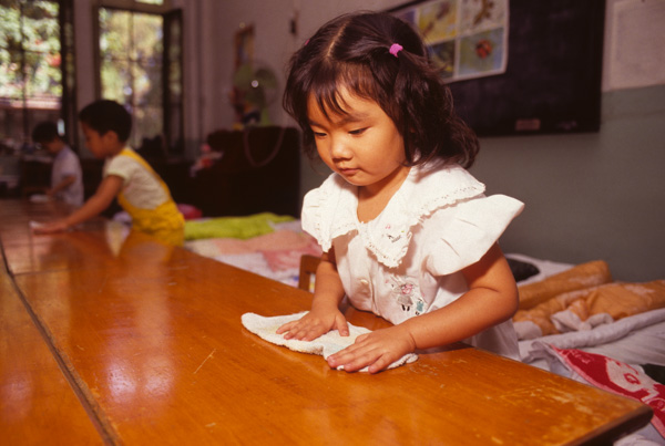 Child cleans table at kindergarten