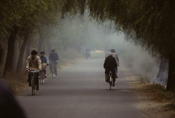 People ride through smoke, Beijing