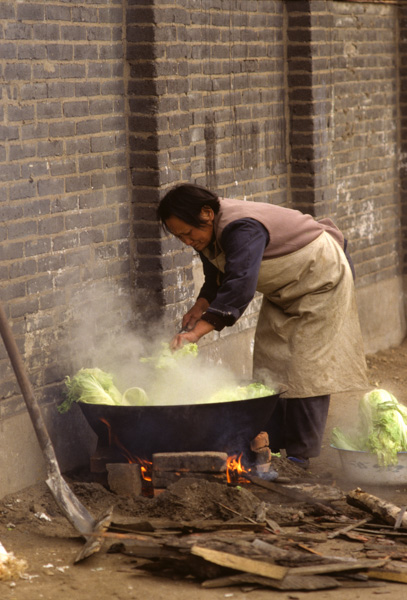 Woman cooks over fire, Shenyang