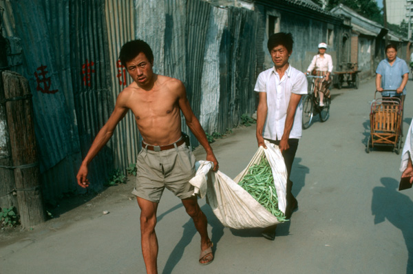 Men carry green beans, China