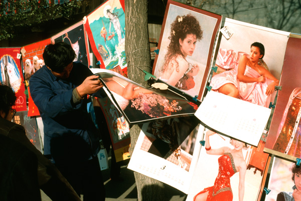 Man Looking at Calendars of Women