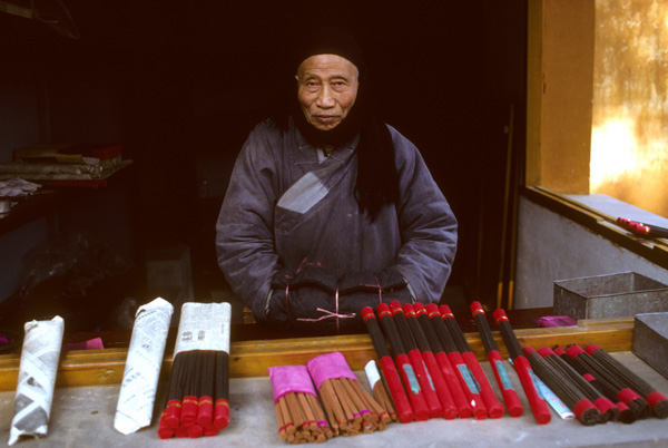 Monk selling incense, Happy Buddha Temple