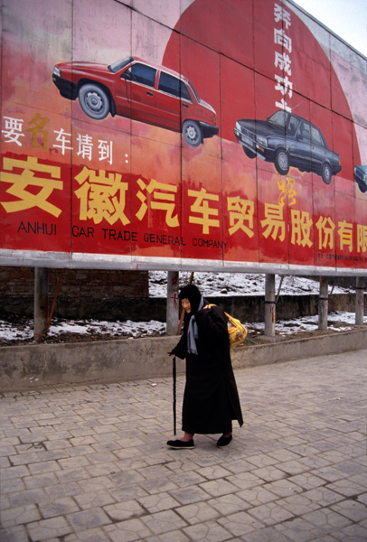Woman walks past car ad