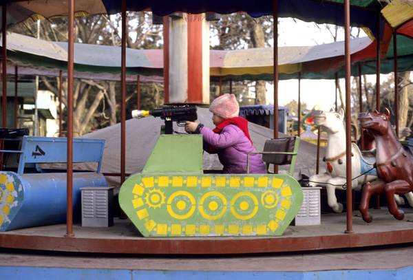 Child on tank amusement park ride