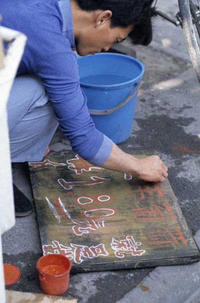 Vegetable vendor makes sign