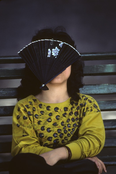 Woman with fan on face