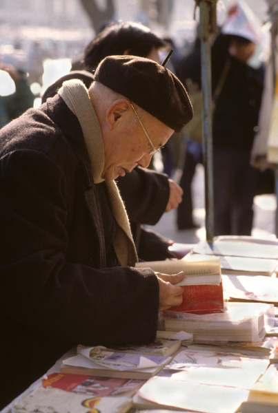 Man reads at book stand