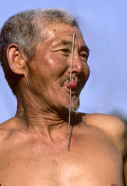 Street performer with spike in tongue