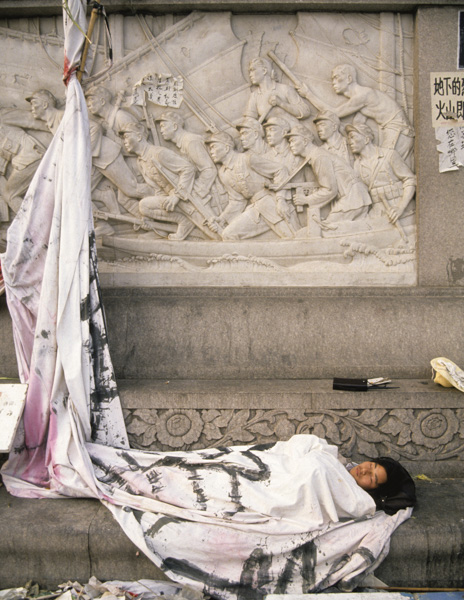 Protester naps wrapped in banner