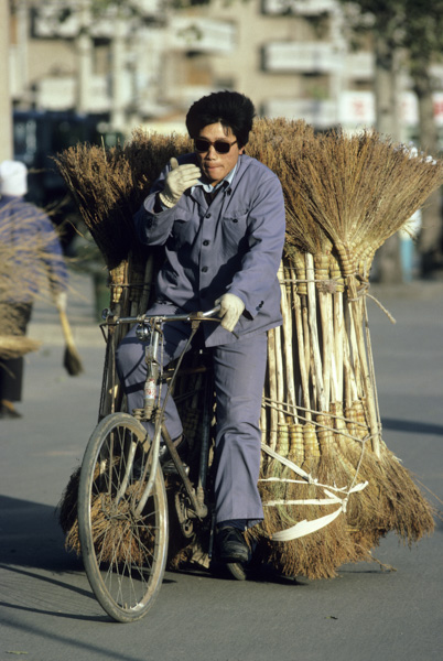 Man hauling brooms