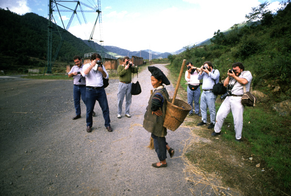 Yi minority woman with news photographers
