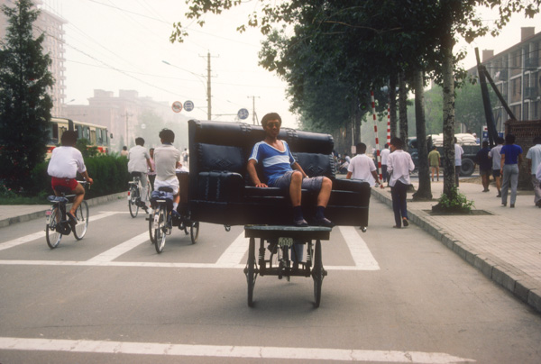Man sitting on couch on bicycle
