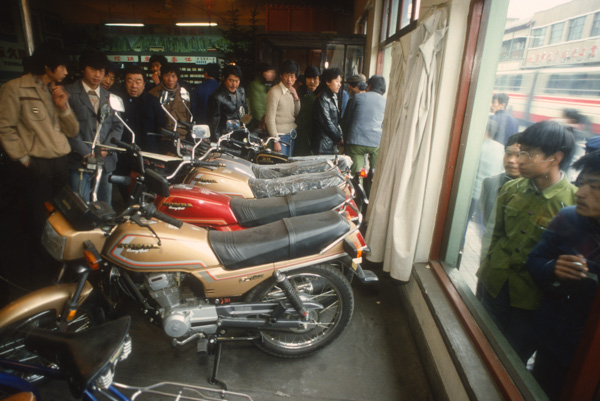 Men looking at motorcycles in shop