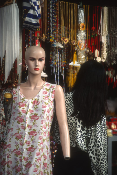 Bald mannequin and woman in market in Forbidden City