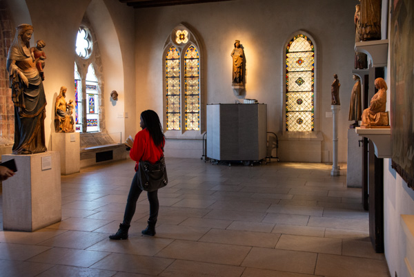 Woman Looking at Statues of Mary