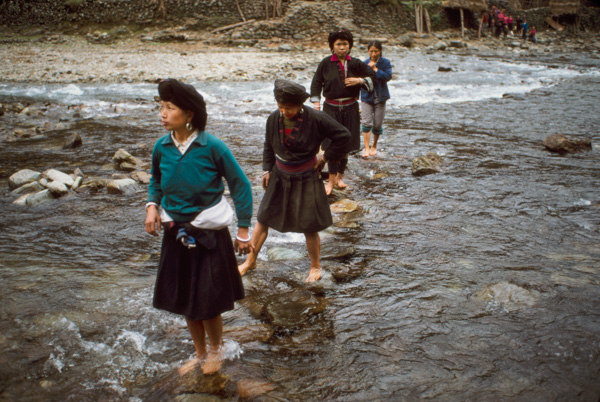 Women crossing river, China