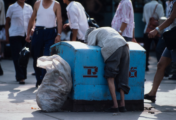 Woman sorts through garbage, China