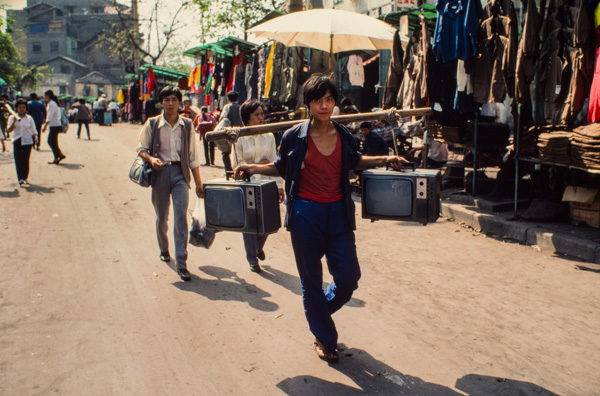 Man with televisions on shoulder pole, Chongqing