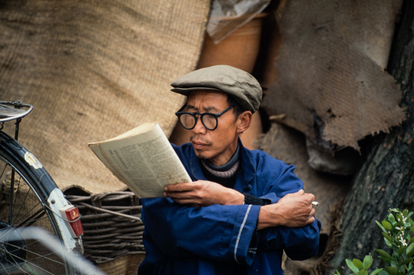 Man reads newspaper, Beijing