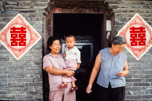 Women and child in courtyard entrance, Beijing