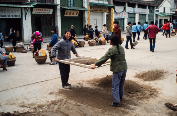 Women sifting dirt, China