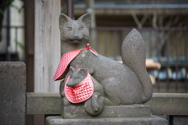 Cat and fox statues with bibs, Sensoji Temple, Tokyo, Japan.