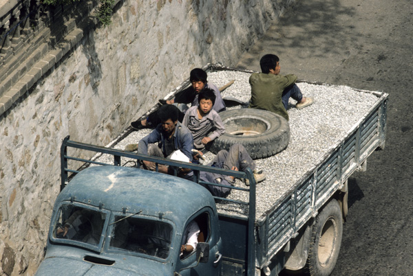 Workers on truckload of gravel