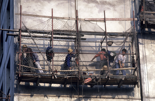 Workers on bamboo and steel scaffolding